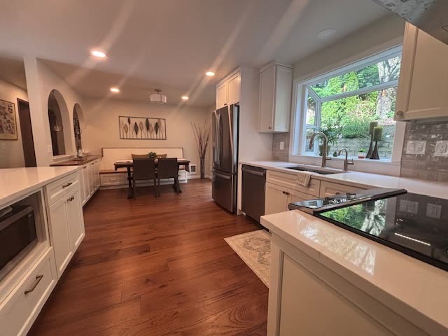 Clinch residence kitchen after remodel — white shaker cabinetry, stainless appliances, marble herringbone backsplash and a garden window over the sink.