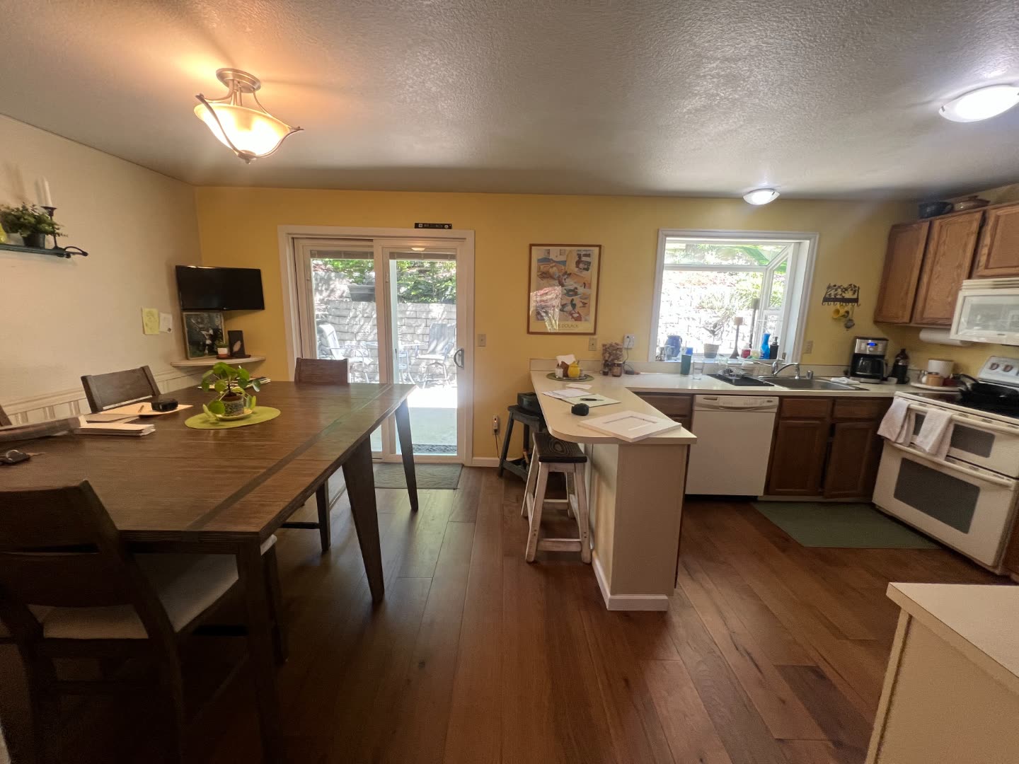 Clinch kitchen before remodel — yellow walls, oak cabinetry, white appliances and laminate counters.