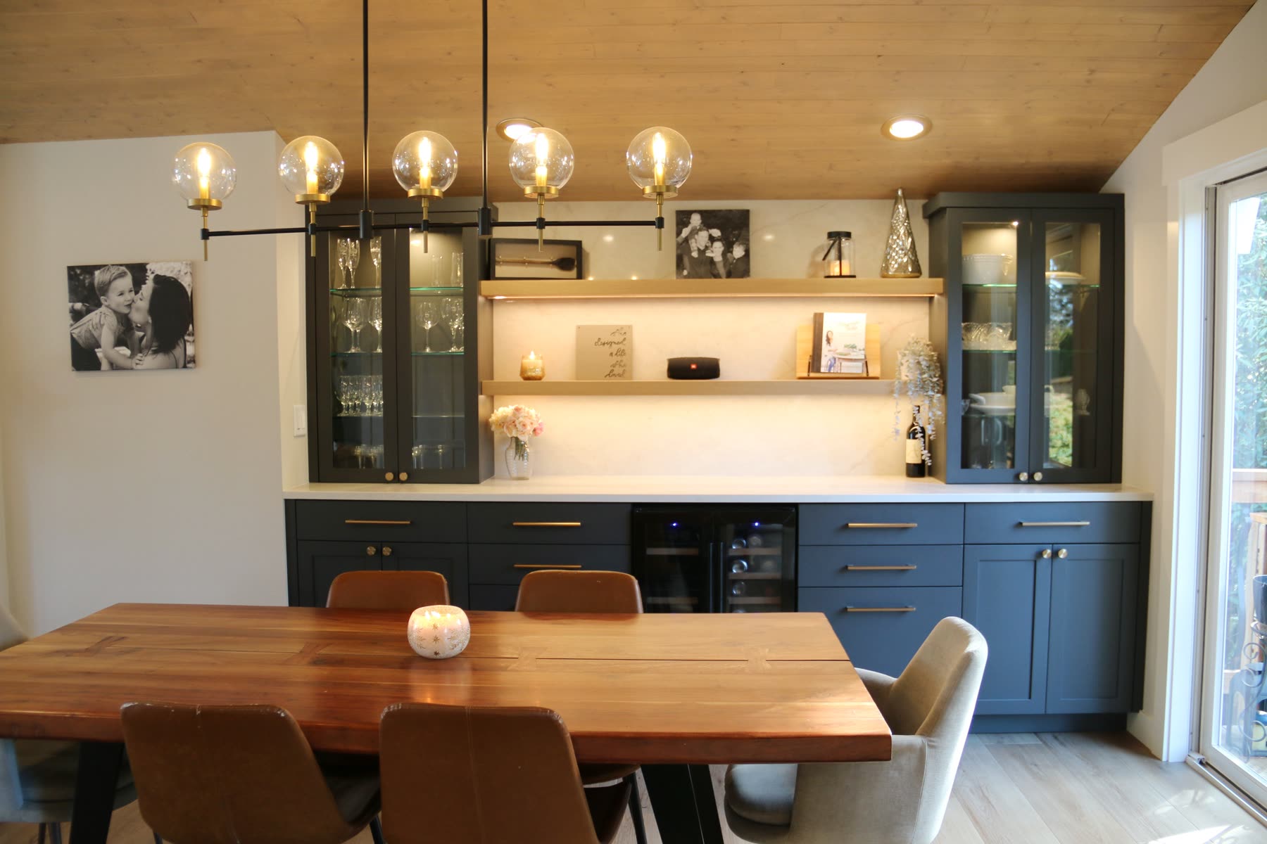 Navy and oak butler's pantry with brass globe pendants and live-edge dining table at Van Buuren Residence.